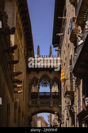 Vertikale Ansicht einer berühmten Brücke zwischen zwei Gebäuden aus der Ferne im gotischen Viertel in Barcelona, Spanien Stockfoto