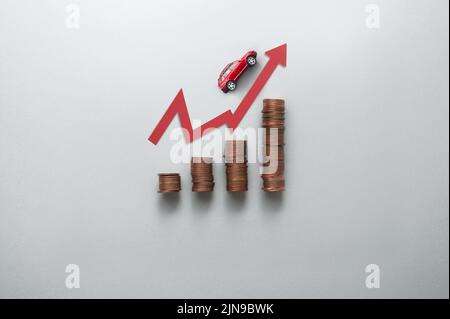 Steigender Benzinpreis Konzept, Business Chart Stapel von Münzen mit Spielzeugauto bewegt sich nach oben entlang Pfeil Stockfoto