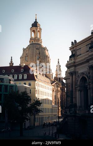 Die Kuppel der Frauenkirche, die im Abendlicht in Dresden-Deutschland hinter anderen Gebäuden aufragt Stockfoto