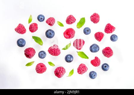 Frische Beeren isolieren sich auf weißem Hintergrund. Isoliertes Makro aus Himbeeren und Heidelbeer-Früchten auf weißem Hintergrund Stockfoto