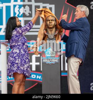 Melanie Mills, Witwe von Sam Mills, dem ehemaligen Linebacker der Carolina Panthers, und Jim Mora Sr, ehemaliger Cheftrainer der New Orleans Saints, enthüllen am 6. August 2022 eine Statuenbüste während der Pro Football Hall of Fame Verbriefungszeremonie im Tom Benson Stadium in Canton, Ohio. Die Wähler hatten 8 Mitglieder für die PFHOF-Klasse von 2022 ausgewählt. Stockfoto