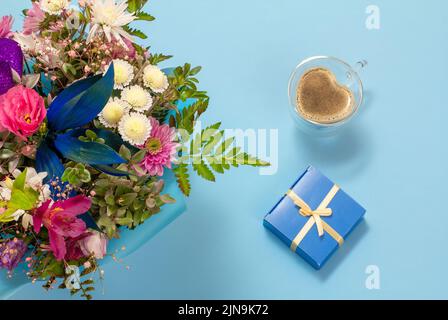 Tasse Kaffee und Geschenkbox mit Blumen. Stockfoto