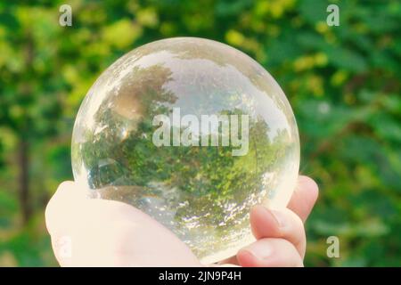 Eine Hand, die eine Glaskugel hält Stockfoto