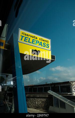 Telepass-Mautschilder, die von einem Busfenster aus durch Italien in der Nähe von Pompeji durchfahren werden. Stockfoto