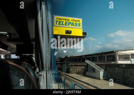 Telepass-Mautschilder, die von einem Busfenster aus durch Italien in der Nähe von Pompeji durchfahren werden. Stockfoto