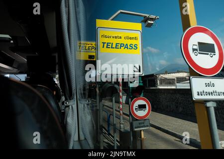 Telepass-Mautschilder, die von einem Busfenster aus durch Italien in der Nähe von Pompeji durchfahren werden. Stockfoto