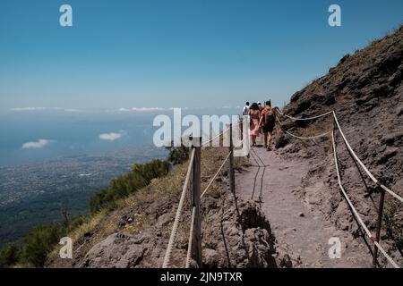 Touristischer Spaziergang entlang des Weges um den Kegel des Vesuv Italien mit der erstaunlichen Aussicht über die Neapel-Gegend auf der linken Seite. Stockfoto