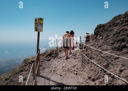 Touristischer Spaziergang entlang des Weges um den Kegel des Vesuv Italien mit der erstaunlichen Aussicht über die Neapel-Gegend auf der linken Seite. Stockfoto