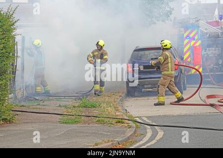 Essex Feuerwehr- und Rettungsdienst Team Arbeitsgruppe Feuerwehrleute in Schutzkleidung arbeiten in gefährlichen und gefährlichen Bedingungen auf Hausbrand England Großbritannien Stockfoto