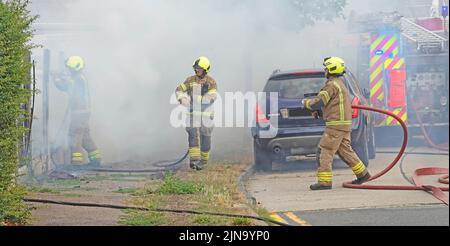 Essex Feuerwehr- und Rettungsdienst Team Arbeitsgruppe Feuerwehrleute in Schutzkleidung arbeiten in gefährlichen und gefährlichen Bedingungen auf Hausbrand England Großbritannien Stockfoto