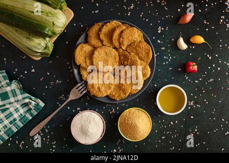 Hausgemachte Zucchini-Chips, zubereitet mit glutenfreier Brotkrume, Reismehl, nativem Olivenöl extra und Salz. Stockfoto