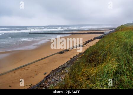 Blick über die verlassene, kaltfeuchte Aberdeen Coast, Nordschottland, mit Sturmwolken, die sich im Hintergrund sammeln. Stockfoto