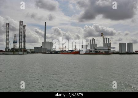 Blick auf Offshore-Ölplattform und Komponenten von Windkraftanlagen auf dem Hafenbecken, Esbjerg, Jütland, Dänemark Stockfoto