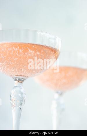 Nahaufnahme von zwei Gläsern rosa Champagner in Champagner-Coupé-Gläsern Stockfoto