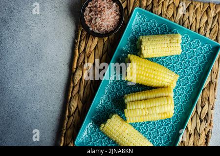 Blick von oben auf frisch gekochte Maiskolben mit rosa himalaya-Salz Stockfoto