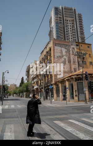 Jerusalem, Israel - 30.. April 2022: Ein orthodoxer jüdischer Mann im Zentrum von Jerusalem an einem samstag, wenn es keine Fahrzeug- oder Handelsaktivitäten gibt. Stockfoto