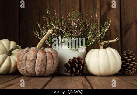 Kogigu (japanischer Butternut-Kürbis), Baby-Boo-Kürbisse, Heideblumen und Zapfen. Herbstzusammensetzung, Herbstdekorationen für Thanksgiving oder Halloween. Stockfoto