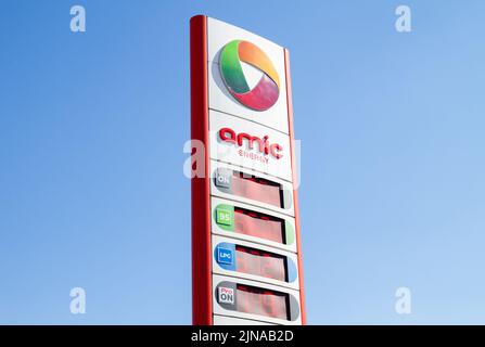 Amic Energy Schild vor einer Tankstelle. Logo auf dem Vorplatz der Tankstelle mit Preisen auf einem Mast. Stockfoto