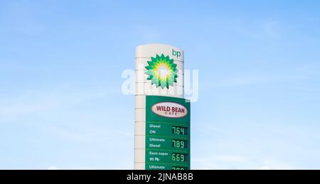 BP-Tankstelle und Wild Bean Cafe. British Petroleum Oil Company Tankstelle, Vorplatz Pylon mit Logo und Preise angezeigt. Stockfoto