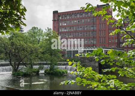 Die East Mill und das Hufeisenwehr am Fluss Derwent in Belper, Derbyshire, Großbritannien Stockfoto