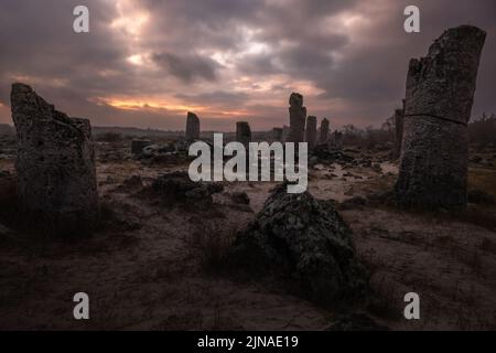 Szenischer Sonnenuntergang mit bewölktem Himmel in der berühmten Pobiti Kamani Wüste mit Felsformationen an der nordwestlichen Grenze der Provinz Varna in Bulgarien. Stockfoto