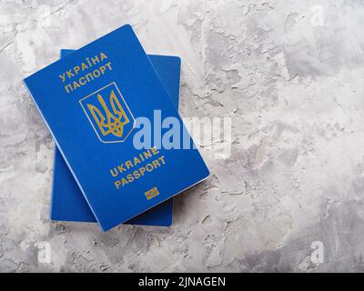 Zwei ukrainische biometrische Pässe auf hellem Hintergrund. Reisen der Ukrainer ins Ausland, Tourismus, Emigration, Flucht aus dem Krieg in der Ukraine. Persönliche id Stockfoto