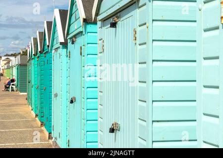 Eine Reihe von mehrfarbigen Strandhütten aus Holz am Meer in Bournemouth Dorset, Großbritannien Stockfoto