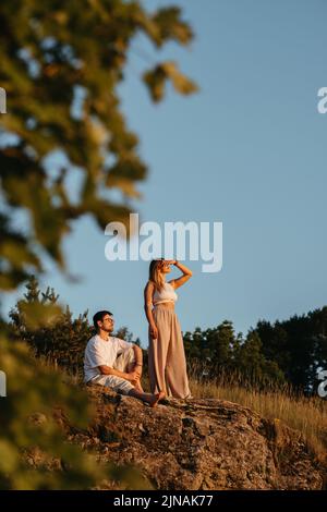 Junge Erwachsene Paar, Mann und Frau genießen schönen Sonnenuntergang im Freien in der Natur Stockfoto