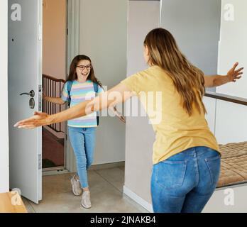 Kind Mutter Tochter Rucksack Haus Bildung Schule Familie Student willkommen Umarmung zusammen liebe Frau elementare Hause Mädchen Frau Stockfoto