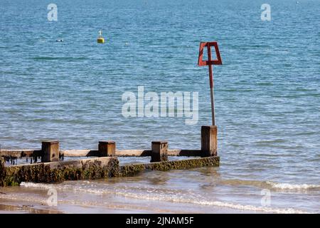 Groyne und Marker am Swanage Beach im Sommer, Dorset, England Stockfoto