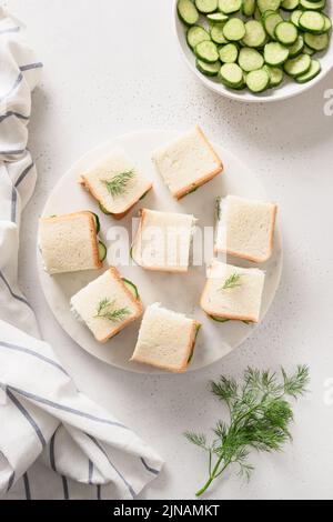 Gurken-Sandwiches mit Ricotta und Dill auf weißem Hintergrund. Draufsicht. Speicherplatz kopieren. Vertikales Format Stockfoto