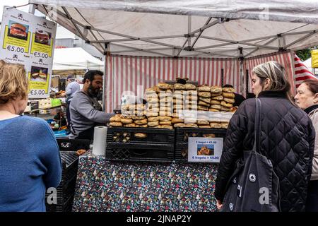 Schlange für Brot an einem Marktstand in der St. Nicholkirche in Galway, Irland. Stockfoto