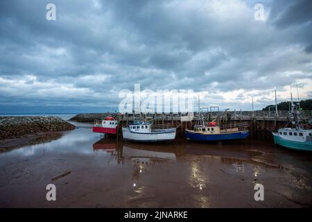 Am Mittwoch, den 6. Juli 2022, sitzen im Hafen von Alma, New Brunswick, Hummer-Fischerboote auf dem Meeresboden. Stockfoto