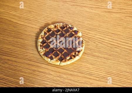 Waffel mit Schokolade auf einem Holztisch. Stockfoto