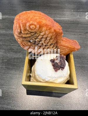 Nahaufnahme von frischen heißen roten BienenTaiyaki in Holzbehälter mit Vanilleeis und roten Bohnen Stockfoto