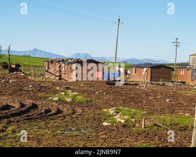 Minderwertige Unterkünfte für ländliche Arbeiter mit Waschanlagen am Zaun im ländlichen Südafrika Stockfoto