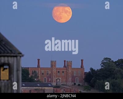 Eastchurch, Kent, Großbritannien. 10. August 2022. UK Wetter: Der fast volle Sturgeon-Mond - der letzte Supermond von 2022 - über dem historischen Shurland Hall-Torhaus in Eastchurch, Kent. Kredit: James Bell/Alamy Live Nachrichten Stockfoto