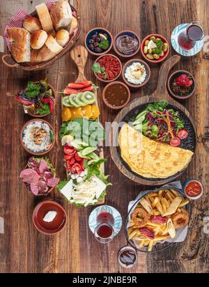 Traditionelles türkisches Frühstück mit traditionellem türkischen Tee auf Holztisch. Frühstück oder Brunch Tisch mit allen Arten von köstlichen Delikatessen gefüllt Stockfoto