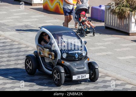Umweltfreundlicher Renault Twizy Elektro-Mikrowagen Seitenansicht von oben, angetrieben von einem männlichen Fahrer auf einer englischen Straße mit weiblicher Beifahrerin Stockfoto