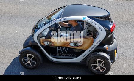 Umweltfreundlicher Renault Twizy Elektro-Mikrowagen, Seitenansicht von oben, von einem männlichen Fahrer auf einer englischen Straße gefahren Stockfoto