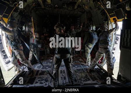 Zwei Ladereister der US-Luftwaffe, die dem Special Operations Wing 352d zugewiesen wurden, öffnen Seitentüren, um sich auf einen statischen Liniensprung mit Dienstmitgliedern der U.S. Army 10. Special Forces Group (Airborne) und Mitgliedern der Zapovjedništvo specijalnih snaga (Croatian Special Operations Forces Command) vorzubereiten. Von einem MC-130J Commando II der US Air Force, das der SOW 352d in der Nähe von Udbina, Kroatien, zugewiesen wurde, 20. Juli 2022. Der Static Line Jump war Teil eines Joint Combined Exchange Training (JCET), zu dem Mitglieder des 352d Special Operations Wings der US Air Force, des 1. Bataillons der US Army, 10. Special, gehörten Stockfoto