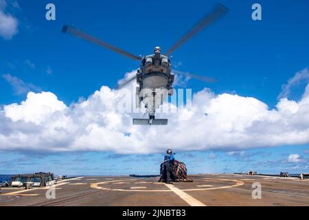 220622-N-UJ411-1007 PAZIFISCHER OZEAN (22. Juni 2022) Seaman Alvin Moe, aus New York, Und Seaman Rich Dilone aus New York bereitet sich darauf vor, während einer vertikalen Auffüllbohrung auf dem Flugdeck des Lenkflugkörper-Zerstörers USS Spruance (DDG 111) der Arleigh Burke-Klasse (US Spruance) Fracht an einen MH-60R Sea Hawk-Hubschrauber zu befestigen, der den „Raptors“ von Helicopter Maritime Strike Squadron (HSM) 71 zugewiesen wurde. Die Abraham Lincoln Carrier Strike Group führt derzeit Routineoperationen in der US 3.-Flotte durch. (USA Navy Foto von Mass Communication Specialist 3. Class Taylor Crenshaw) Stockfoto