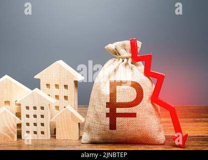 Häuser und russischer Rubel Geldbeutel mit Pfeil nach unten. Senkung der Kosten, Energieeffizienz, Einsparungen. Sinkende Immobilienmarktpreise. Realty Stockfoto