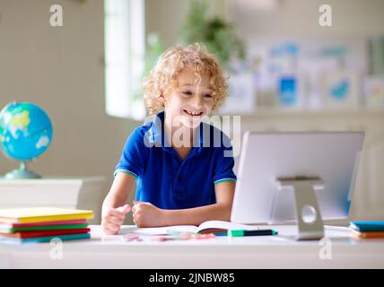 Online-Fernunterricht. Schulkinder mit Computer mit Videokonferenz-Chat mit Lehrer und Klassengruppe. Kind, das von zu Hause aus lernt. Stockfoto