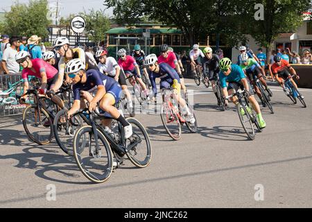 Radfahrer im Peloton, die eine Runde des Criterium fahren, ein Radrennen, bei dem die Radfahrer auf einer Rennstrecke in Bowness Calgary, Kanada, fahren Stockfoto