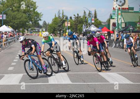 Weibliche Radsportlerinnen fahren auf einer Runde des Criterium, einem schnellen Radrennen, bei dem die Frauen ihre Fahrräder auf einem Rundkurs durch die Straßen der Stadt in Calgary, Kanada, fahren Stockfoto