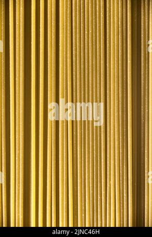 Italienische gesunde Lebensmittel Hintergrund, rohe Spinat Spaghetti füllen den Rahmen in einem strukturierten Design aus grünen vertikalen Pasta-Linien. Stockfoto