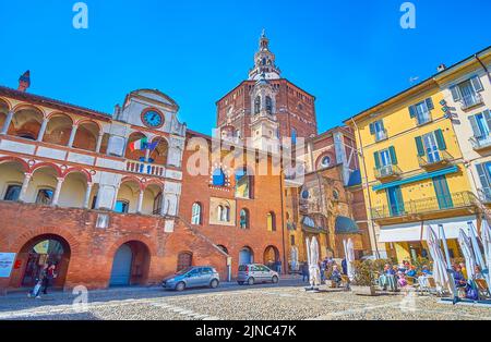 PAVIA, ITALIEN - 9. APRIL 2022: Schöner mittelalterlicher Palazzo Broletto und die Kuppel der Kathedrale, am 9. April in Pavia, Italien Stockfoto