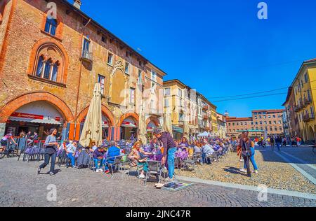 PAVIA, ITALIEN - 9. APRIL 2022: Entspannen Sie sich am 9. April in Pavia, Ita, in einem der Freiluftrestaurants auf der Piazza della Vittorio, dem wichtigsten touristischen Zentrum der Stadt Stockfoto