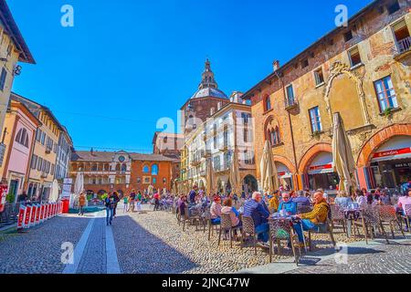 PAVIA, ITALIEN - 9. APRIL 2022: Restaurants auf Piazaa della Vittorio mit einem herrlichen Blick auf die umliegenden mittelalterlichen Paläste und Villen, am 9. April in Pavia Stockfoto